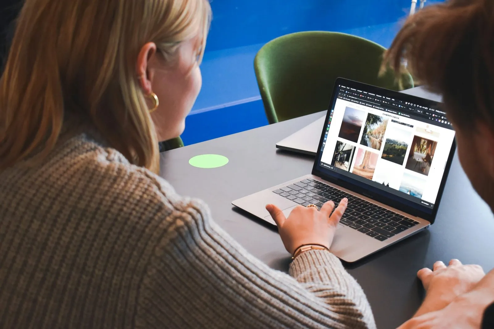 To kolleger kigger sammen på et webdesign på en bærbar computer
